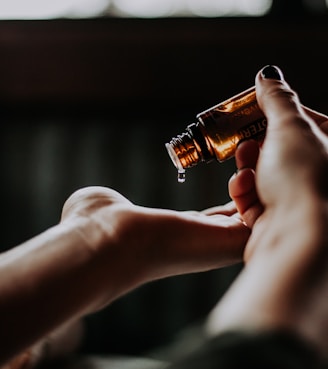 person holding amber glass bottle