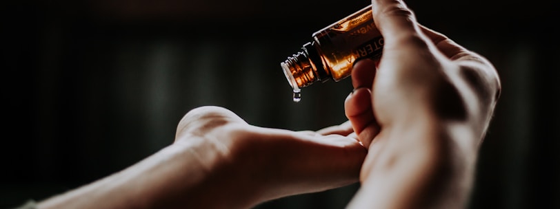 person holding amber glass bottle