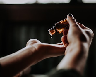 person holding amber glass bottle