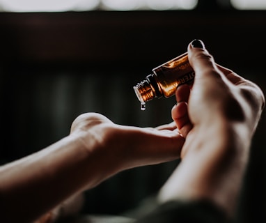 person holding amber glass bottle