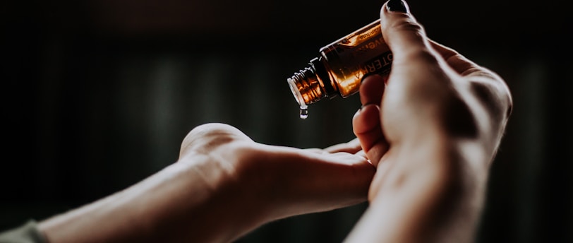 person holding amber glass bottle