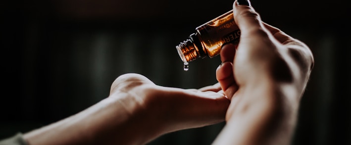 person holding amber glass bottle