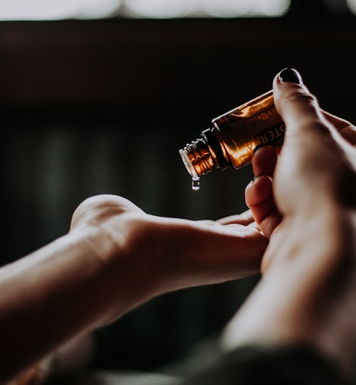 person holding amber glass bottle