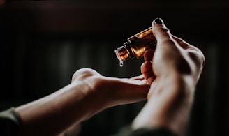 person holding amber glass bottle