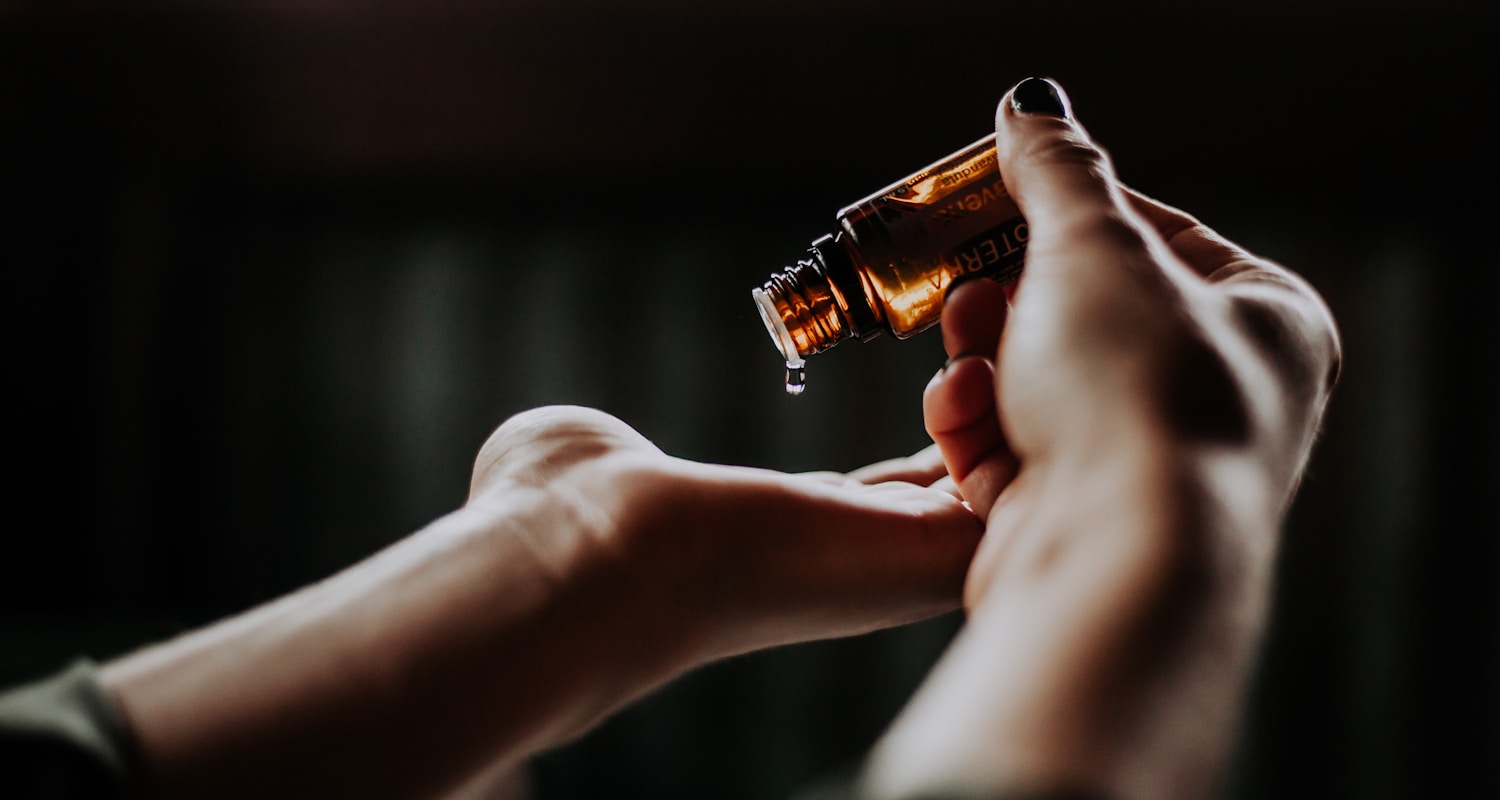 person holding amber glass bottle