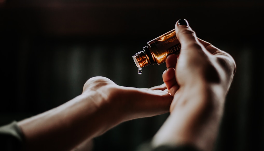 person holding amber glass bottle