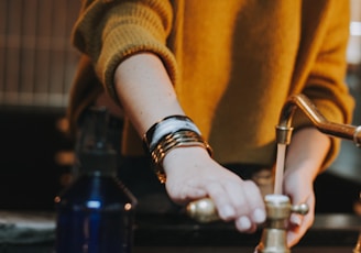 photo of woman holding brass-colored faucet