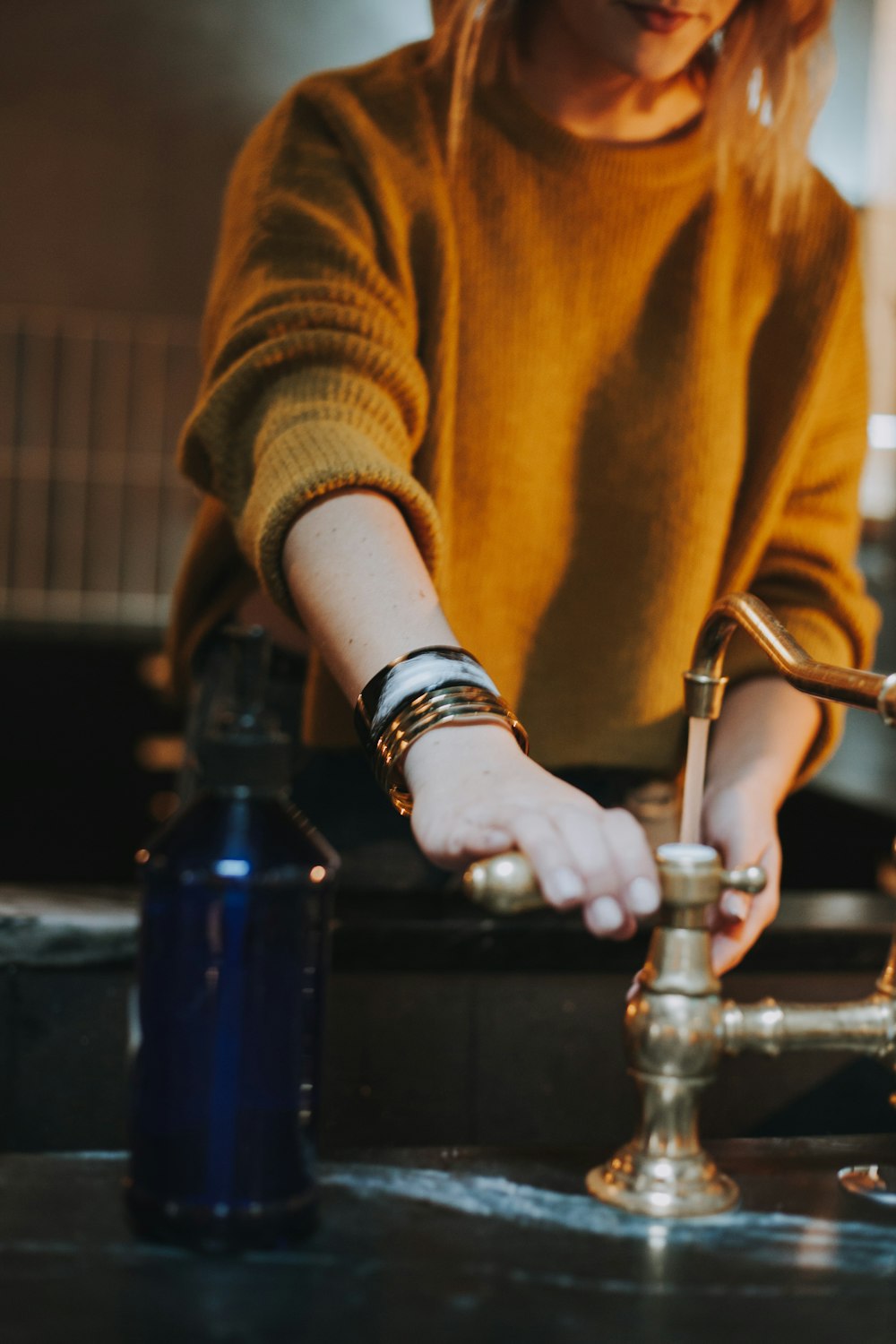 photo of woman holding brass-colored faucet