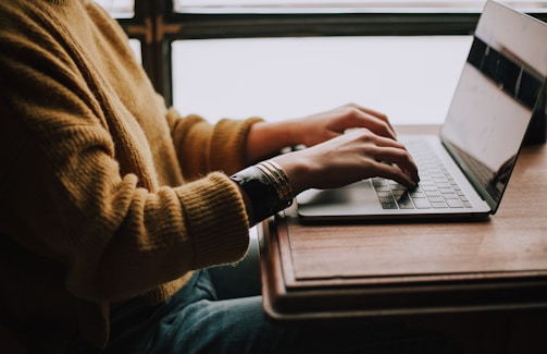 person sitting front of laptop in midst of digital operations work