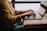 A thoughtful woman working on a laptop in a cozy, sunlit workspace.