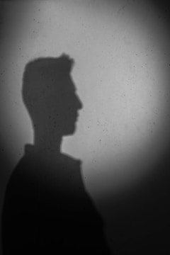 A shadowed silhouette of Trump with legal papers and court sketches in the background.