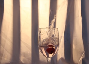 Splash of juicy acerola cherry juice captured mid-air against a clean white backdrop