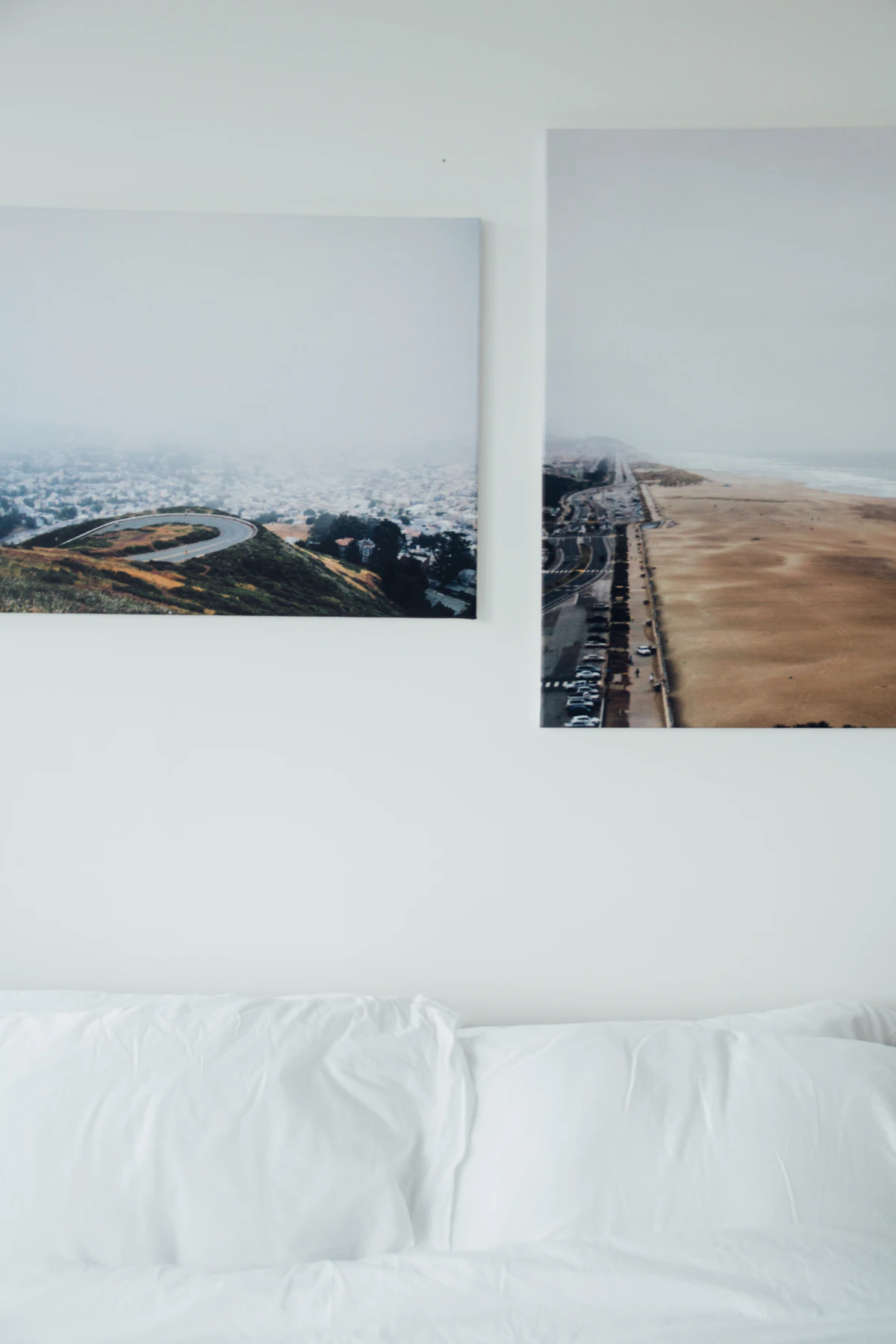 Two frameless gallery-wrapped canvas prints above a bed