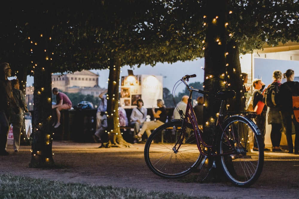 Fotografia de foco raso de bicicleta estacionada ao lado de árvore