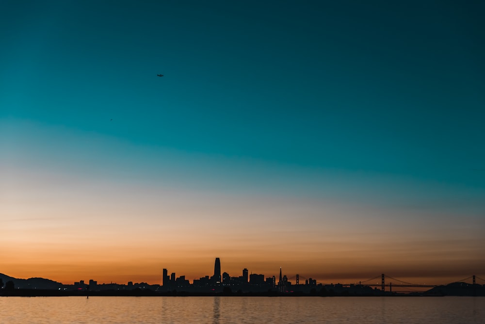 silhouette photography of buildings and body of water