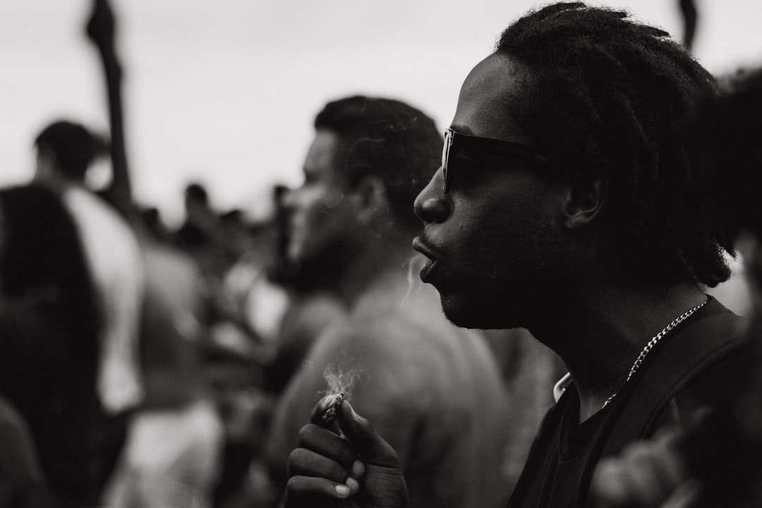 grayscale photography of man holding cigarette