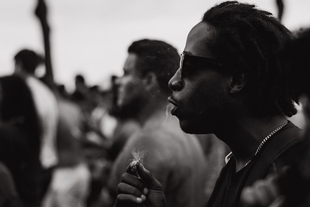 photographie en niveaux de gris d'un homme tenant une cigarette. Les investissements dans le cannabis pourraient apporter le meilleur côté de la vie
