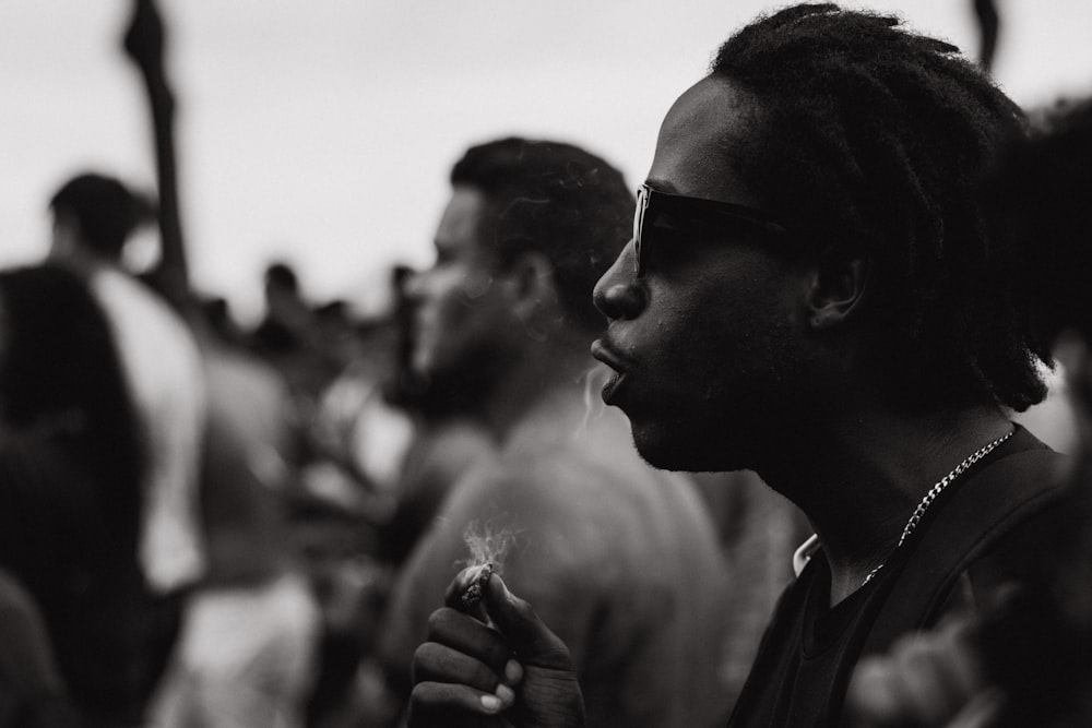 grayscale photography of man holding cigarette