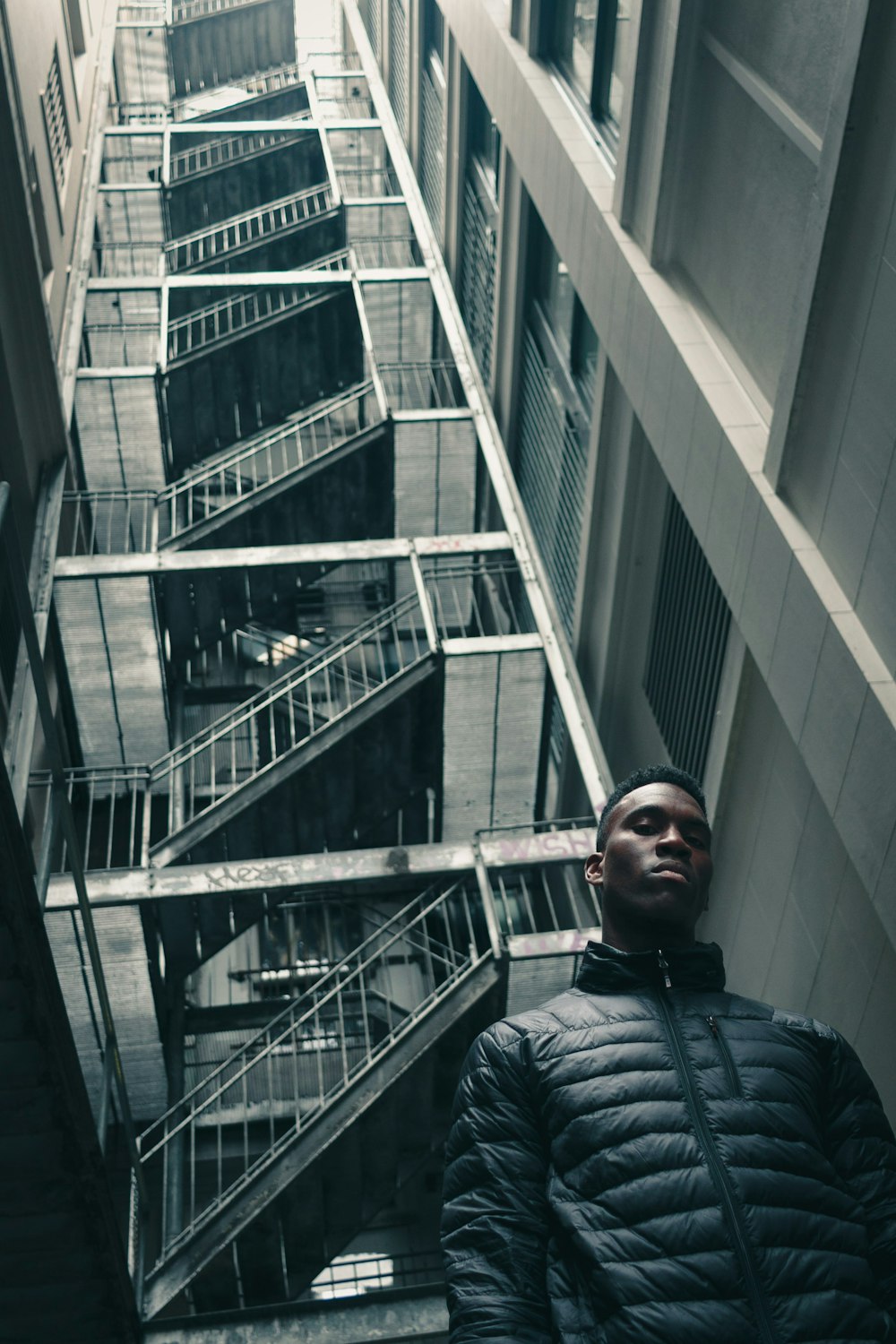 Photographie de vue de l’œil du ver de l’homme debout devant un bâtiment blanc