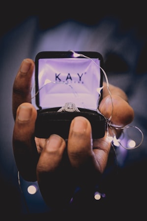 person holding silver-colored ring