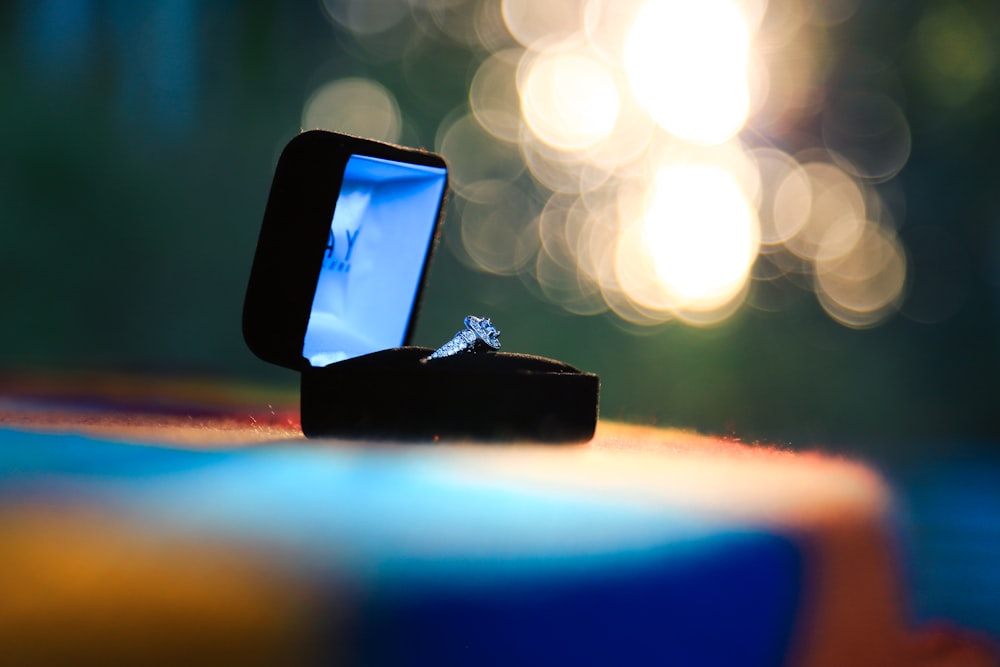 selective focus photography of silver-colored ring in black box