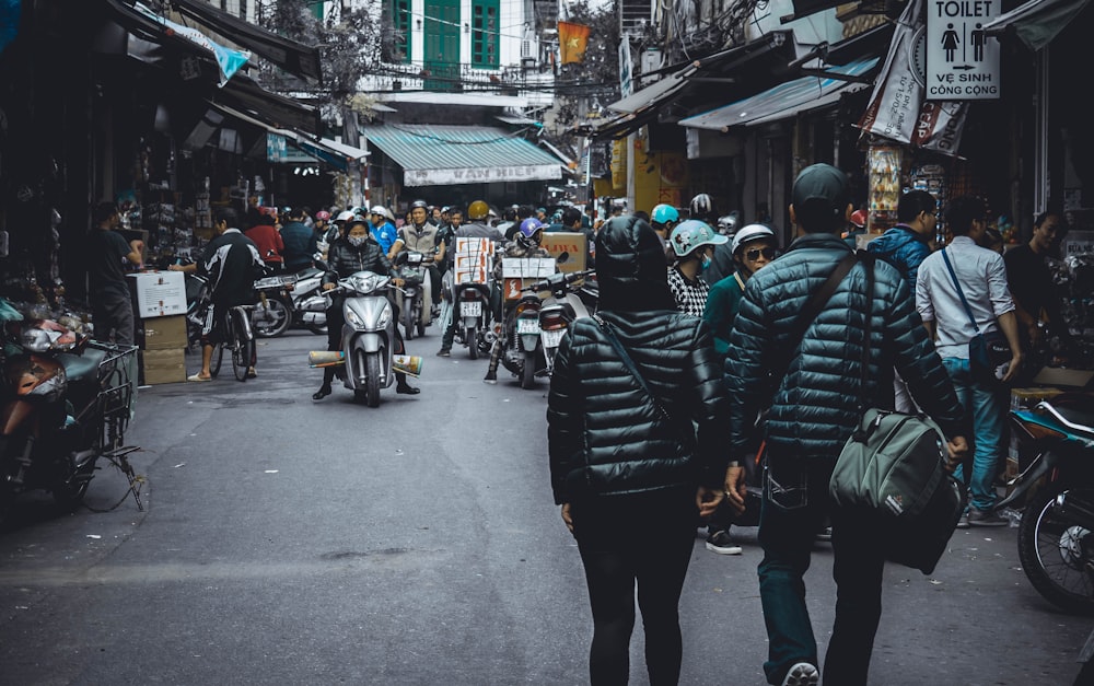 people walking on the street surrounded by concrete structures