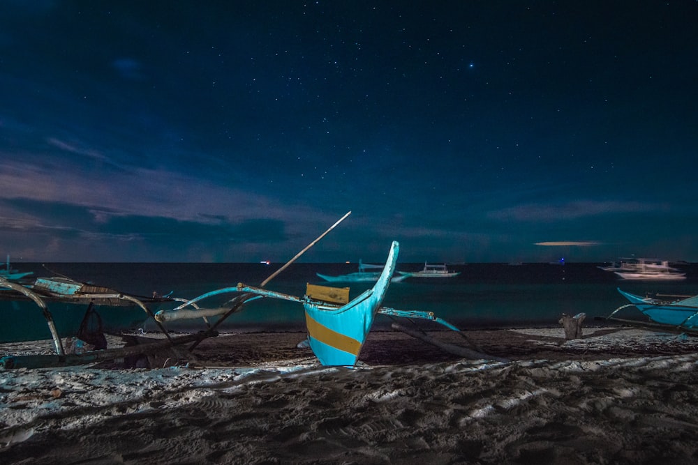 canoe boats near seashore during night