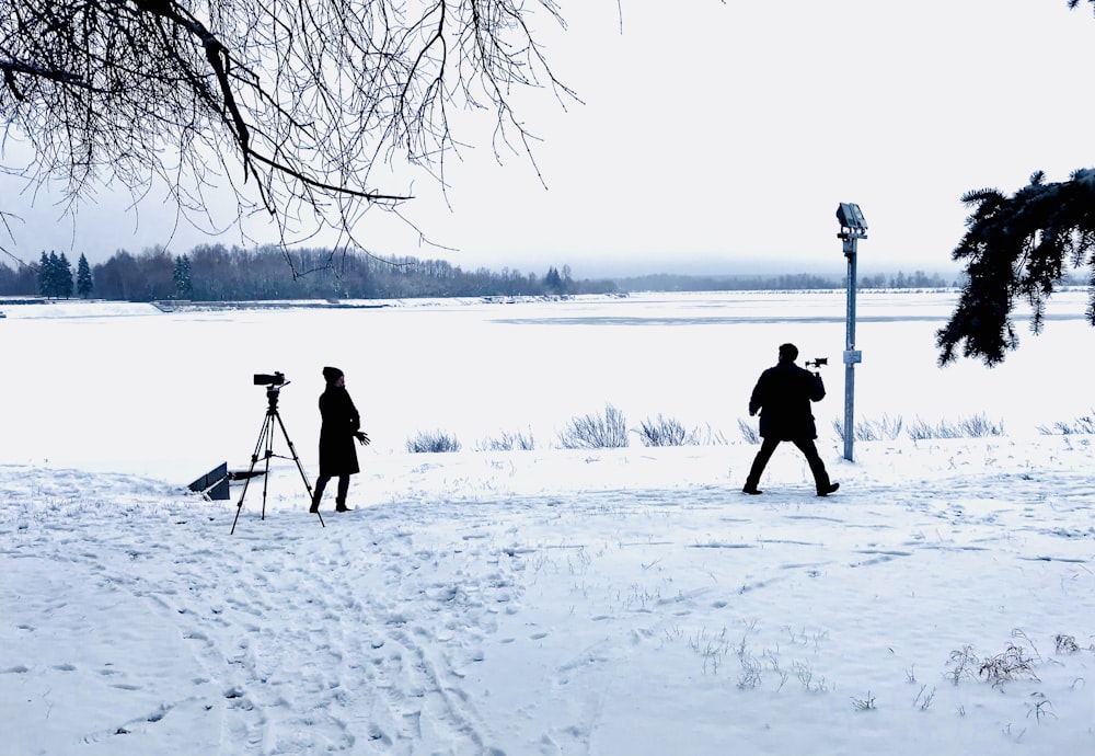 Uomo che filma sul campo di neve