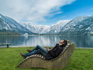 Person relaxing by a mountain lake 