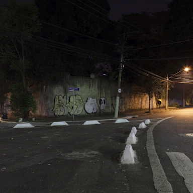 A gritty urban street corner at night with graffiti walls lit by neon lights.