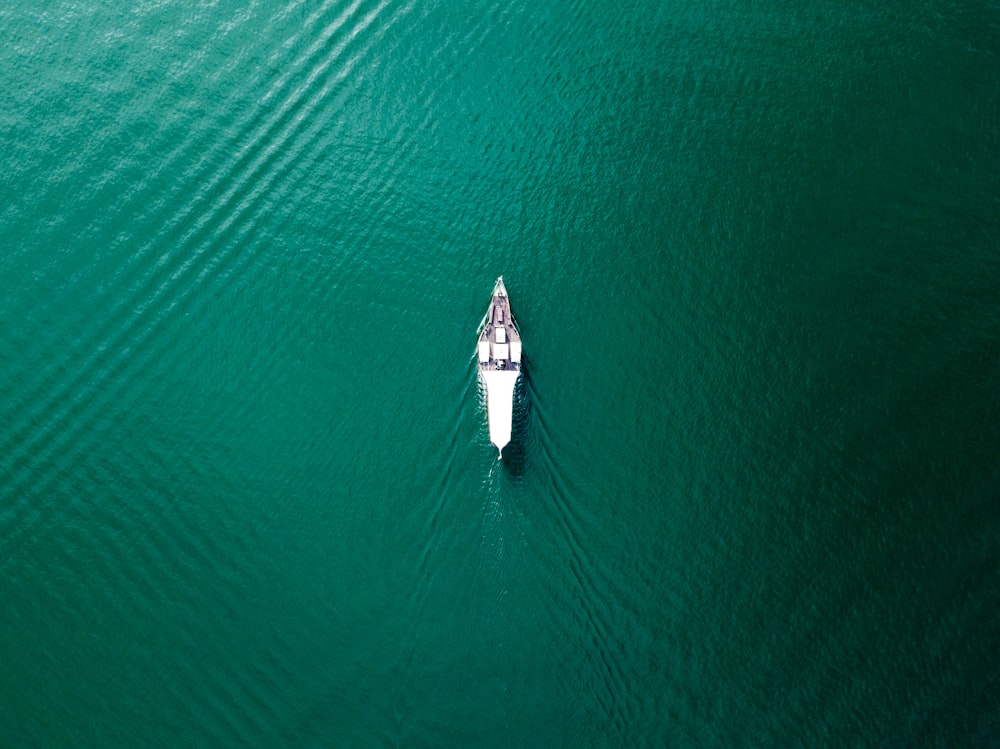 잔잔한 물 한가운데에 있는 하얀 보트의 항공 사진