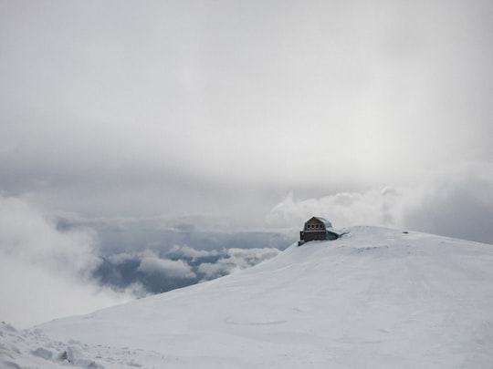 snow covered house under white clouds in Sinaia Romania