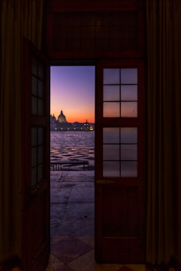 gray dome building near body of water at sunset