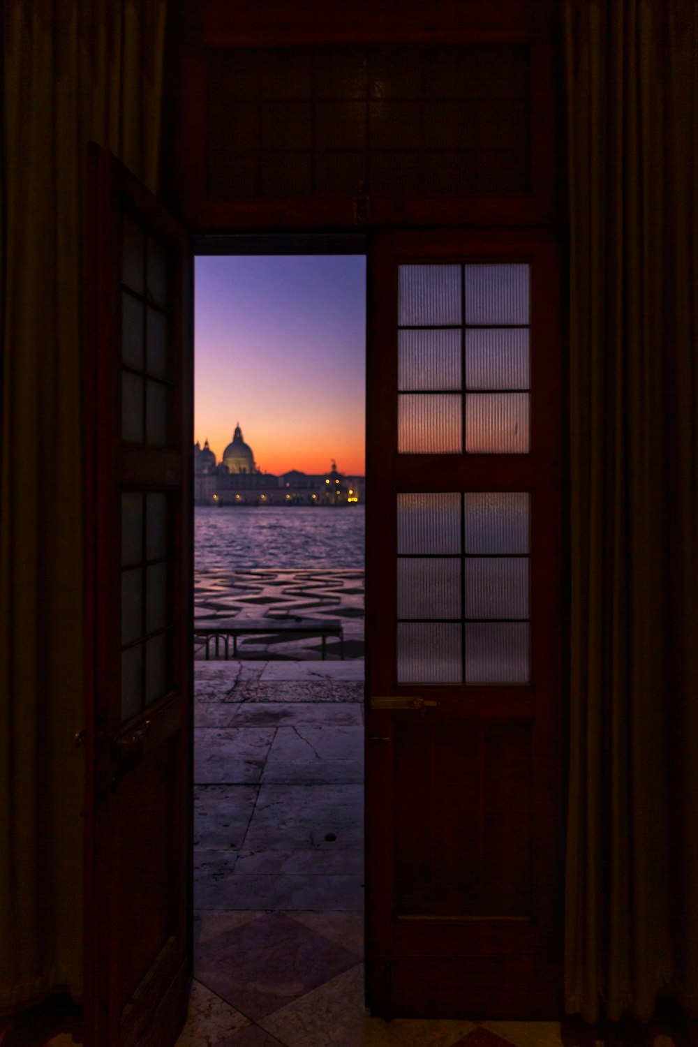 gray dome building near body of water at sunset