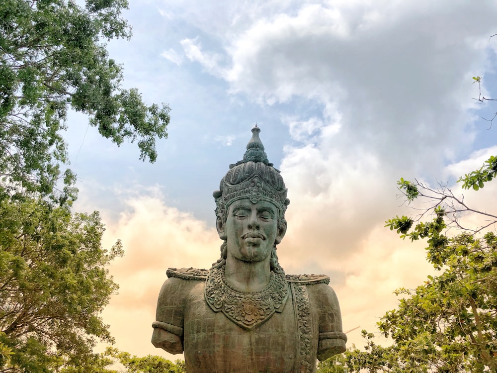 macro photography of statue between trees