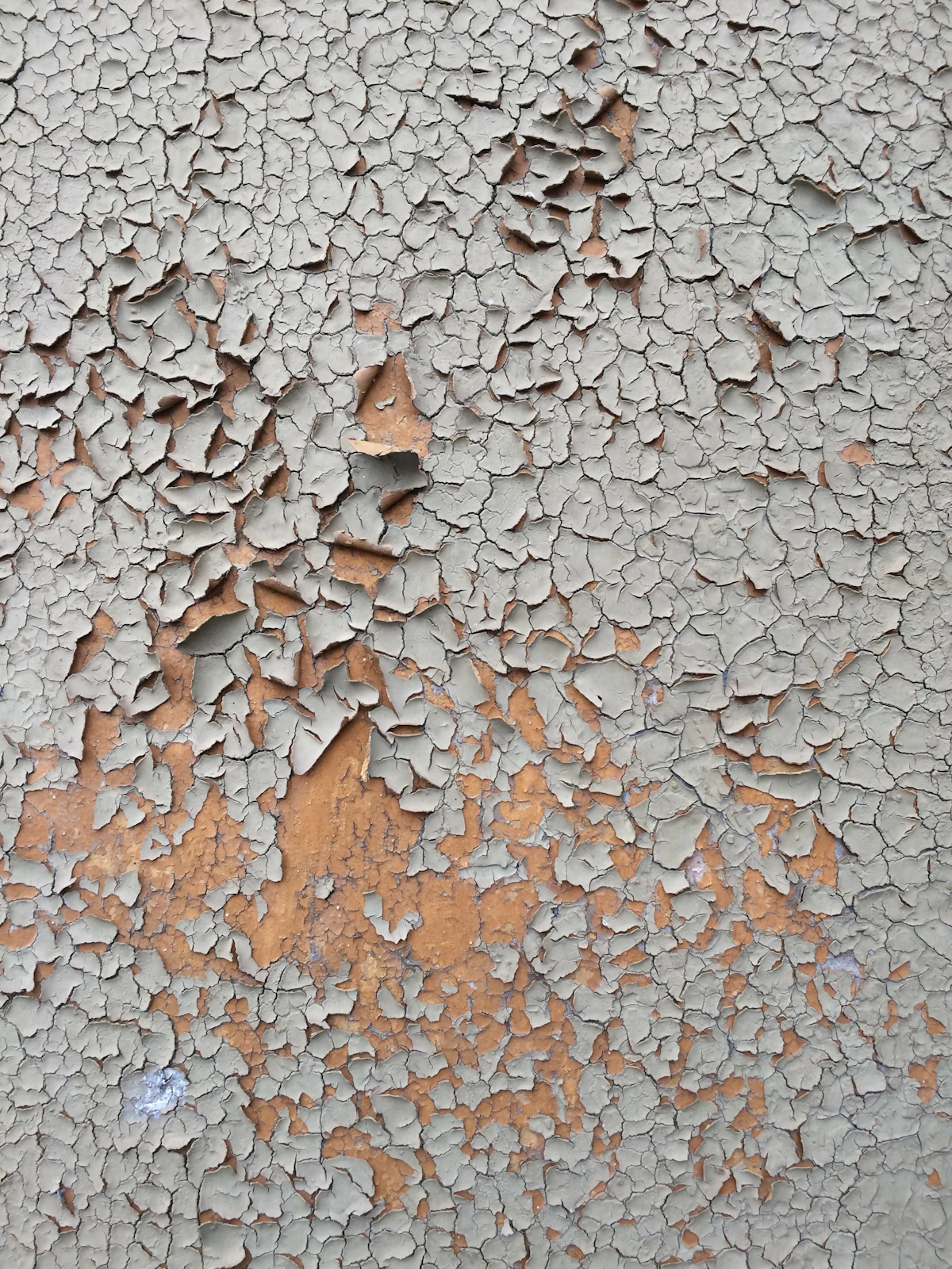 Paint flaking away across a weathered wall