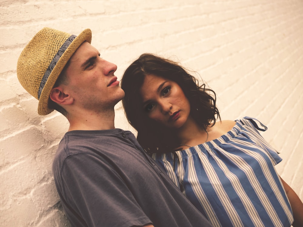 man and woman standing near brick wall