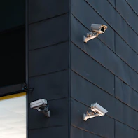 Technician installing a security camera on a building exterior