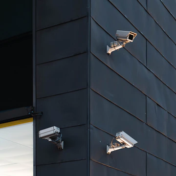 Close-up of a modern security camera mounted on a building corner.