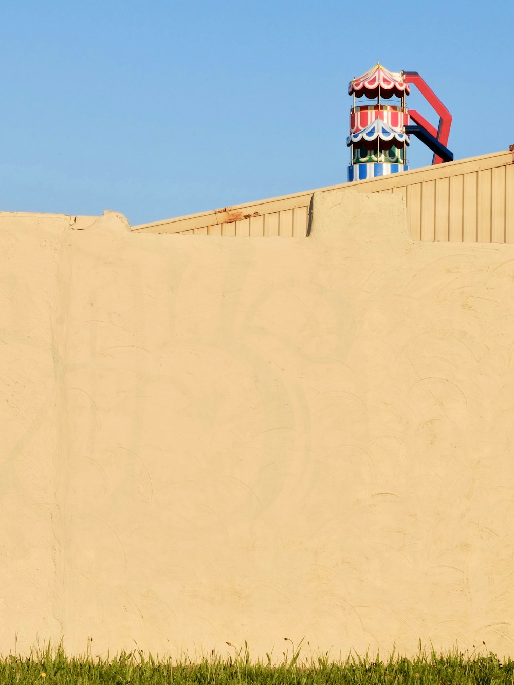 Herbe verte près d’un mur de béton jaune