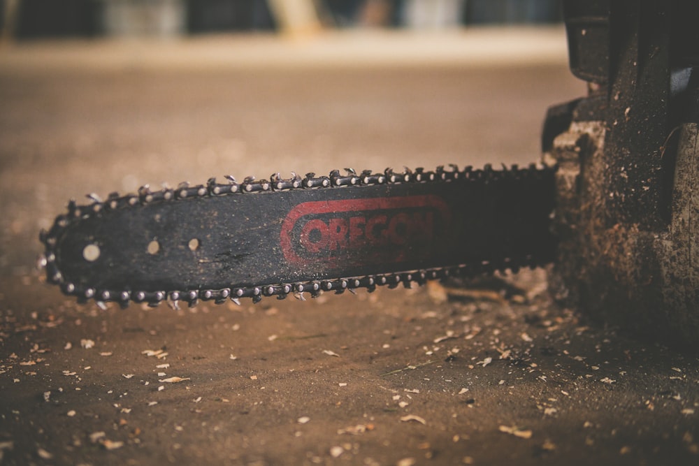 black and red Oregon chainsaw on brown wood plank