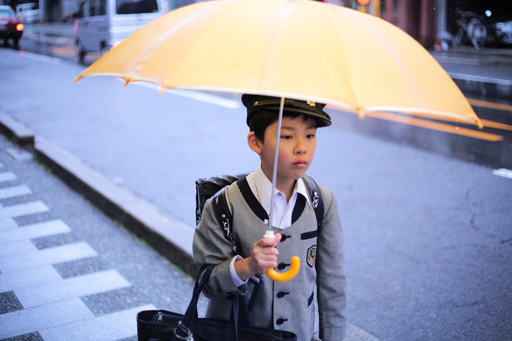 garçon tenant un parapluie jaune