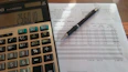 Professional accountant reviewing financial documents with a laptop and calculator in a modern office.