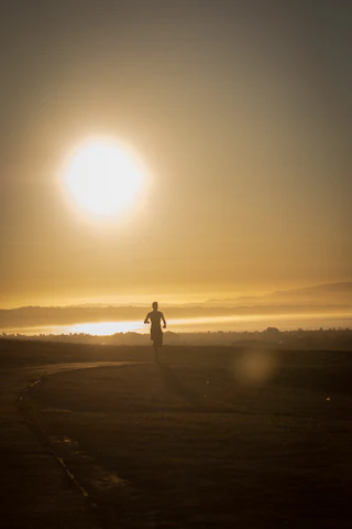 Bakti running along a scenic lakeside trail during sunrise.