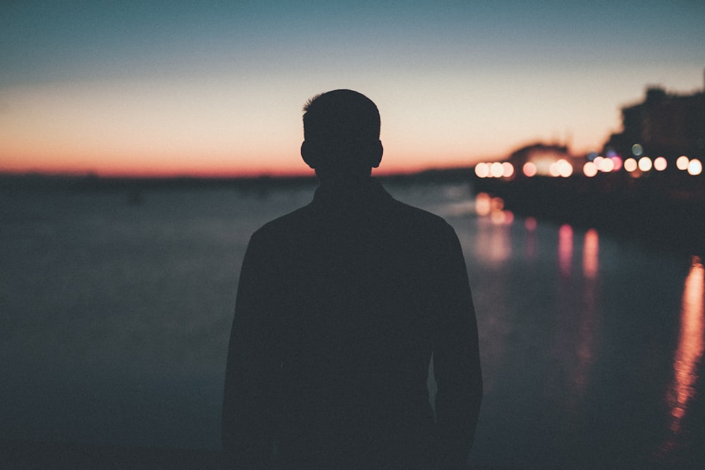 silhouette of man front of sea