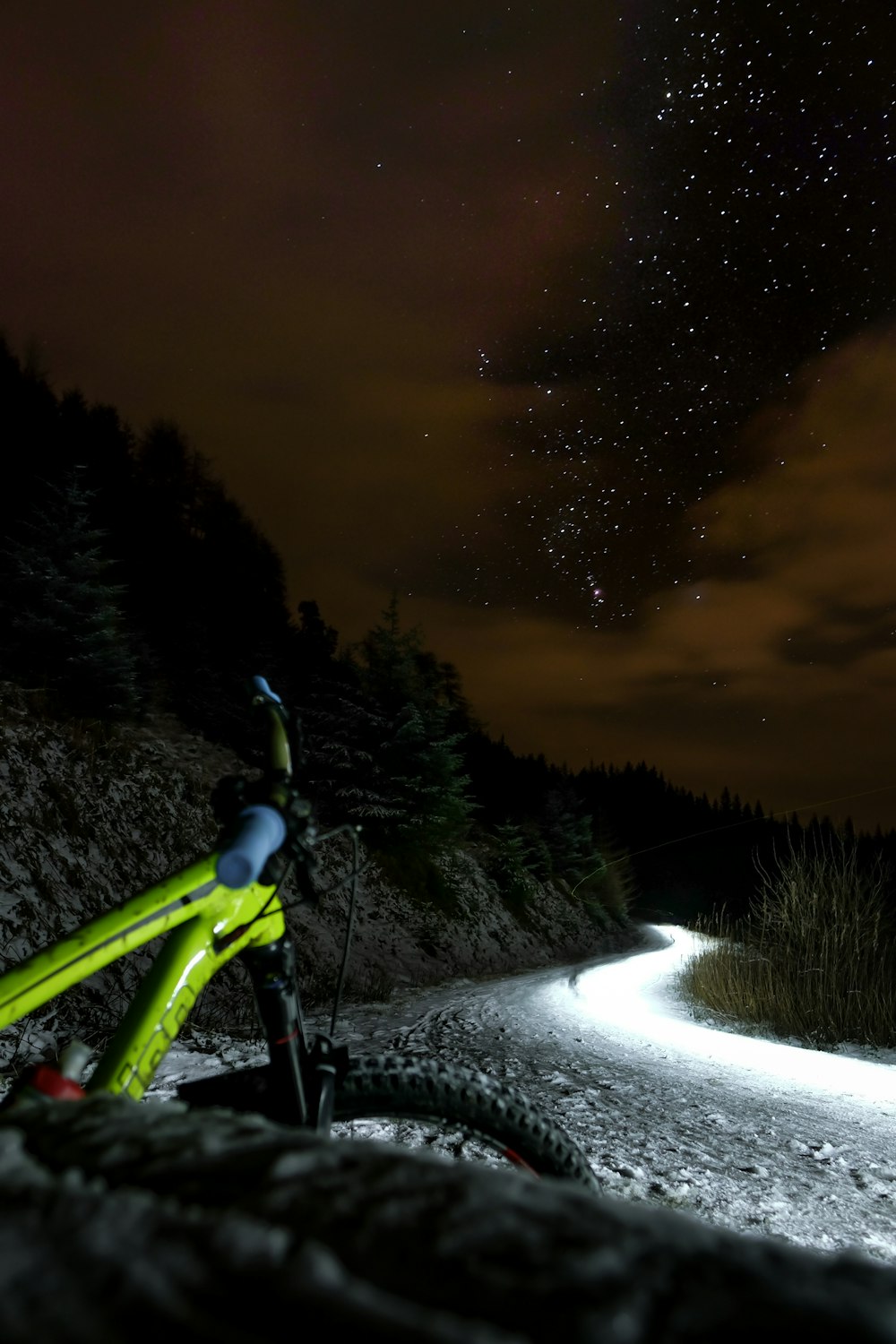 green and black hard-tail mountain bicycle parked beside road