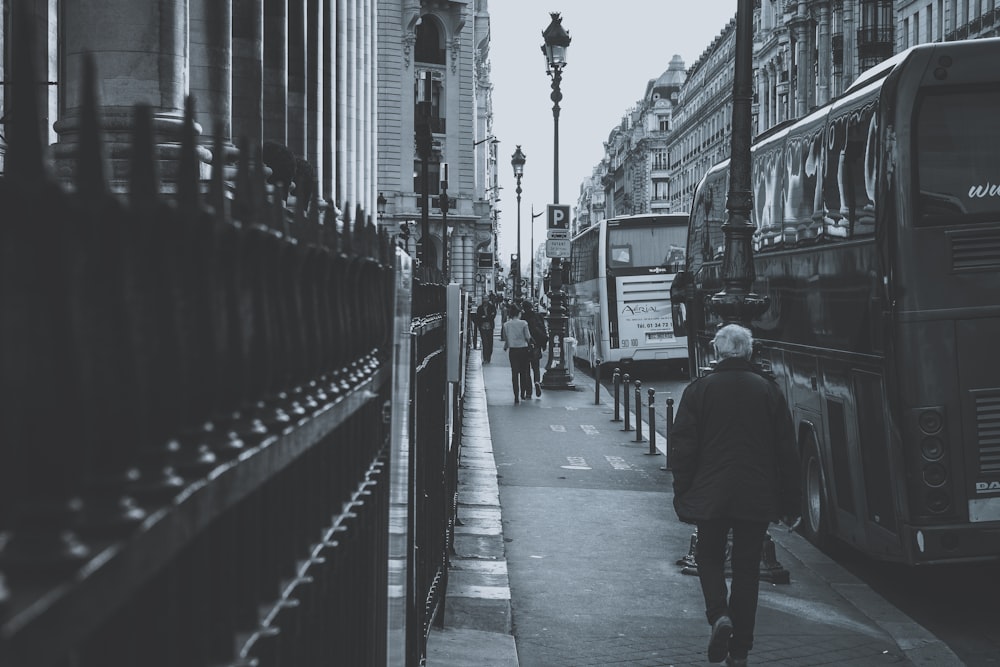 grayscale photography of people walking on sidewalk