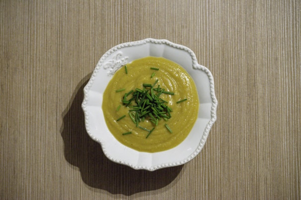 A creamy pastel blue bowl filled with vibrant homemade vegetable soup, garnished with fresh herbs.