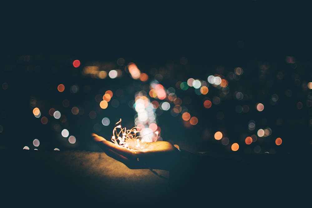 person's hand with light bokeh