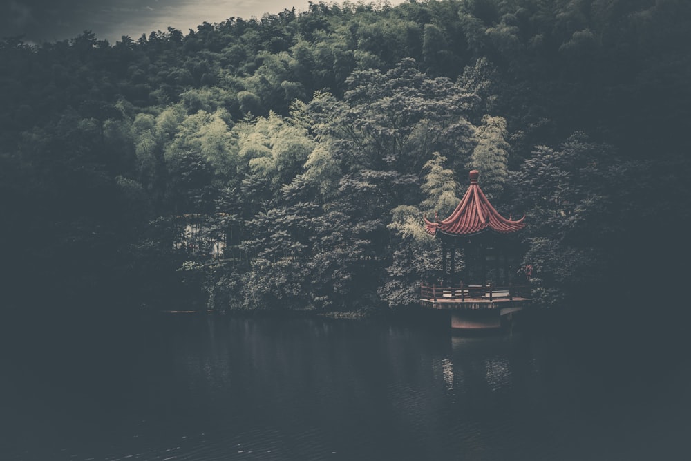 red gazebo on body of water